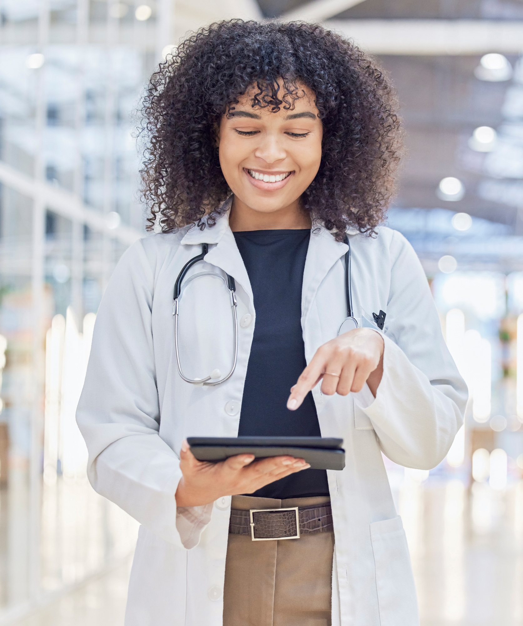 Happy, doctor and woman with tablet for research in hospital, telehealth and healthcare. Technology